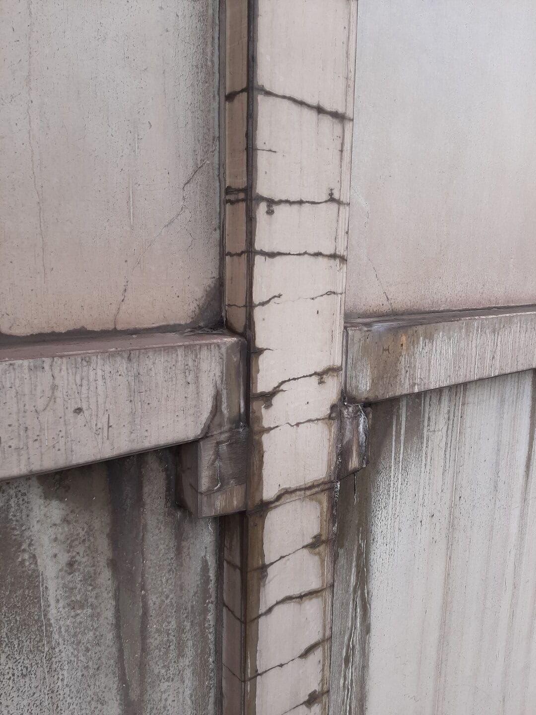 Scheurvorming langs de wapening door corrosie in een betonnen kolom, vastgesteld tijdens technische expertise - Sanacon